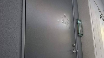 横浜市金沢区釜利谷マンション/凹んだ玄関扉、硬い物でガンガン叩かれた凹み多数です。